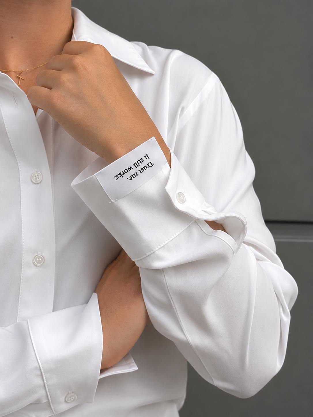 Close-up of the Essence Shirt's oversized cuff, revealing the hidden embroidered message "Trust me. It still works." inside the sleeve, paired with clean tailoring and a smooth, elegant drape.